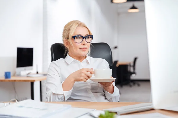 Empresária bebendo café com computador no escritório — Fotografia de Stock