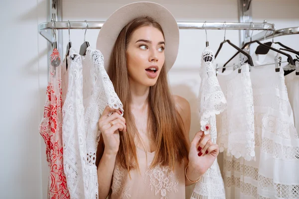 Surprised curious woman standing in clothing store and looking away — Stock Photo, Image