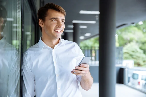 Joven empresario alegre usando el teléfono celular — Foto de Stock