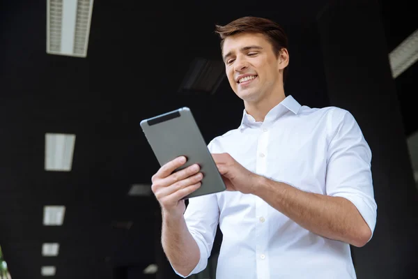 Hombre de negocios alegre de pie al aire libre y el uso de la tableta — Foto de Stock