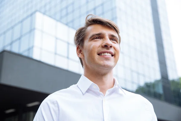 Glada affärsman står nära modern skyskrapa — Stockfoto
