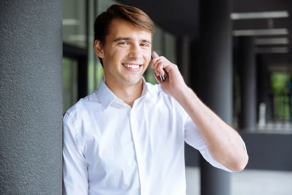 Feliz joven hombre de negocios hablando por teléfono móvil —  Fotos de Stock