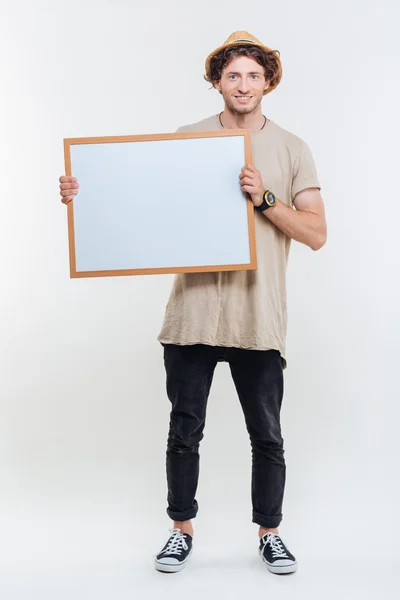 Portrait of a smiling stylish man holding blank board — Stock Photo, Image