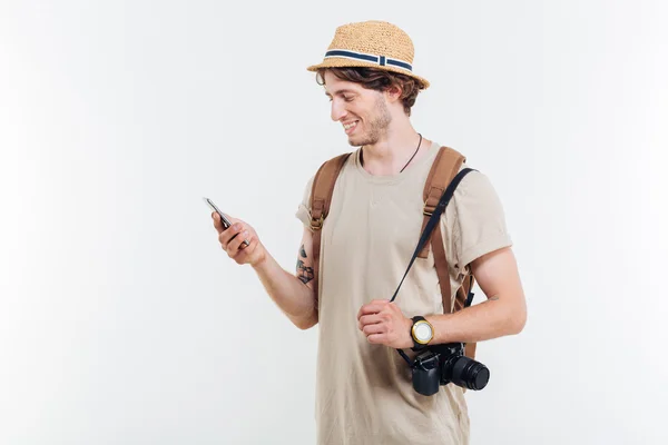 Retrato de un hombre sonriente con mochila usando un teléfono inteligente — Foto de Stock