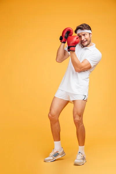 Scared man boxer in red gloves covered face by hands — Stock Photo, Image