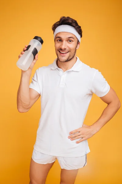 Porträt eines glücklichen Sportlers, der Flasche mit Wasser in der Hand hält — Stockfoto