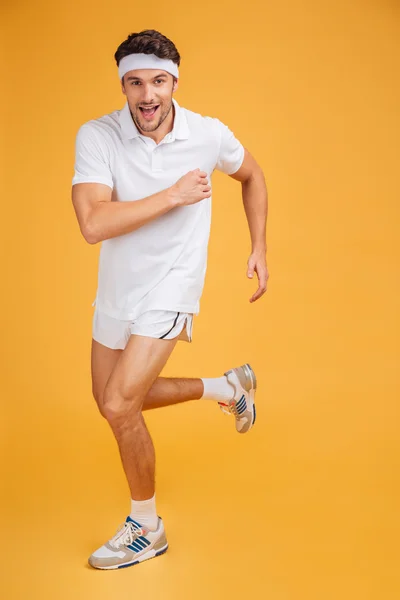 Comprimento total de feliz bonito jovem desportista correndo — Fotografia de Stock