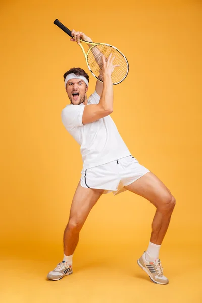Κωμικό παιχνιδιάρικο νέος άνθρωπος τένις παίκτης με ρακέτα που διασκεδάζει — Φωτογραφία Αρχείου