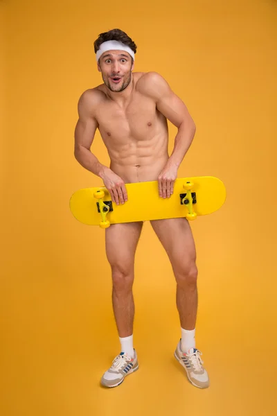 Sportovní mladý nahý muž, který držel skateboard — Stock fotografie