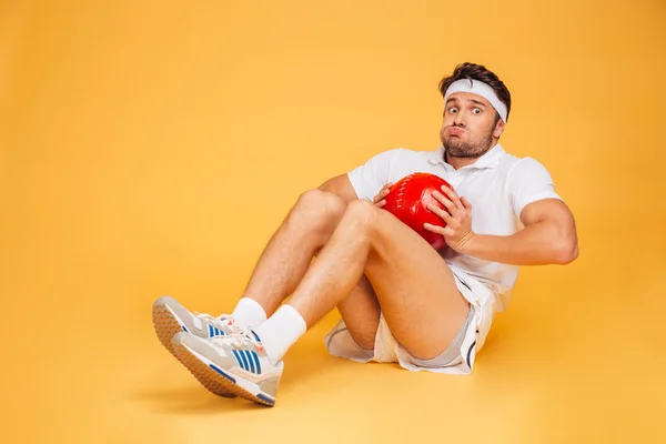 Funny sports man working out with fitness ball isolated