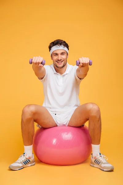 Sportoló férfi fitness labda csinál gyakorlatokat kis súlyzók — Stock Fotó