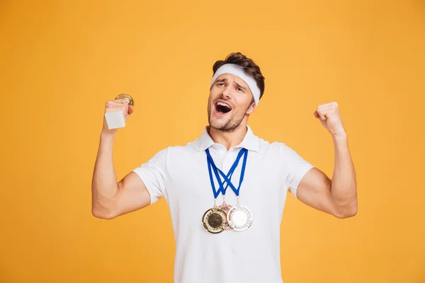 Erfolgreicher Sportler mit drei Medaillen jubelt und feiert Sieg — Stockfoto