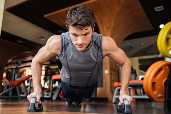 Man athlete training and doing push-ups in gym — Stock Photo, Image