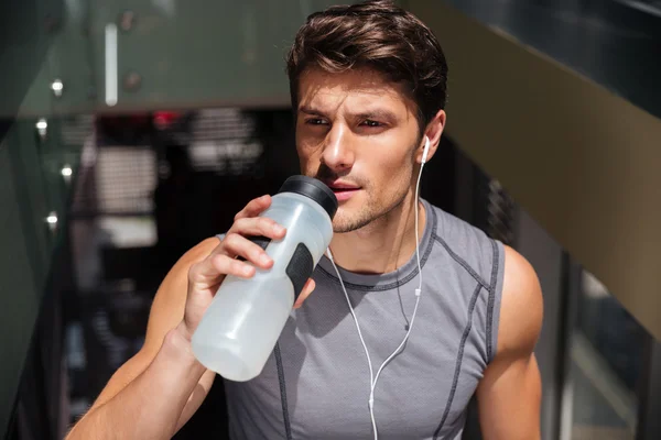 Esportista beber água e ouvir música — Fotografia de Stock