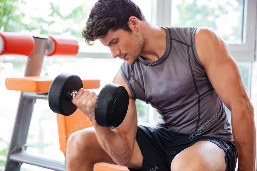 Fitness man working out with dumbbells in gym Stock Photo by