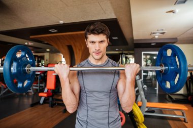 Attracitve genç sporcu halter salonunda kullanarak eğitim