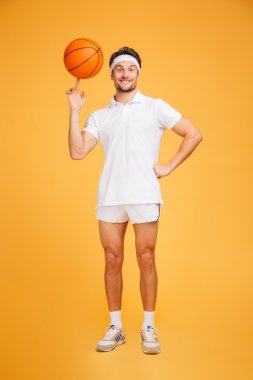 Gülümseyen basketbolcu parmağında dönen topu