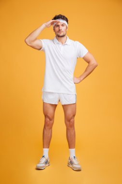 Ciddi yakışıklı genç sporcu ayakta ve fr away bakıyor