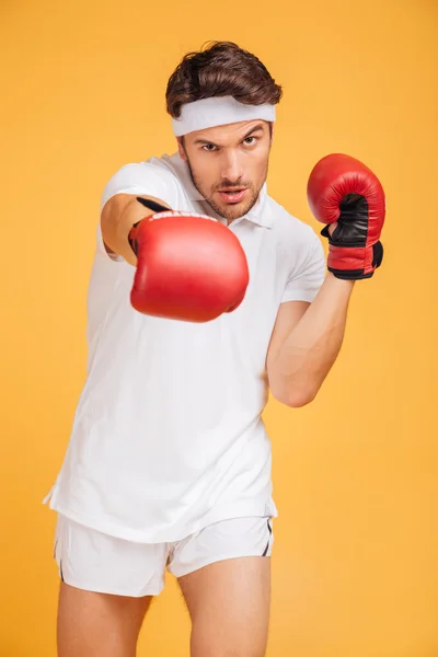 Yakışıklı genç boksör ayakta ve boks kırmızı eldiven — Stok fotoğraf