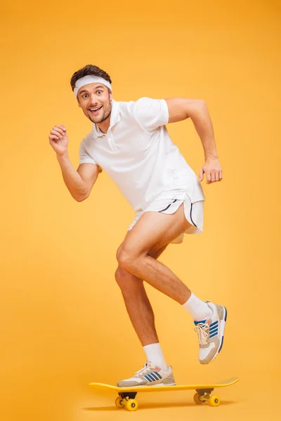 Full length portrait of a happy young sports man skateboarding — Stock Photo, Image