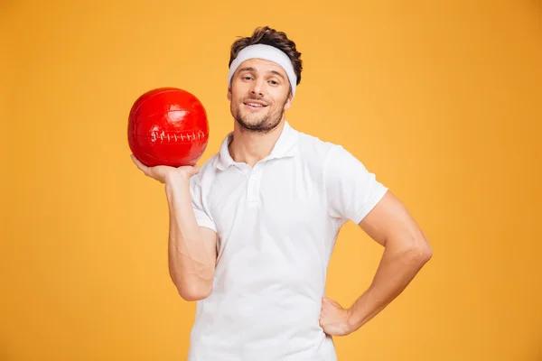 Full längd porträtt av en stilig man med fitness boll — Stockfoto