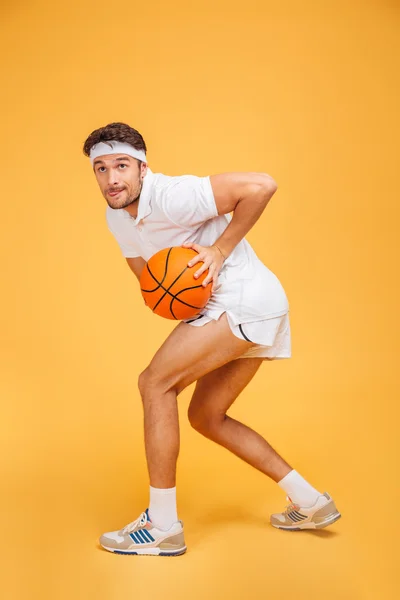Porträt eines hübschen jungen Mannes beim Basketballspielen — Stockfoto