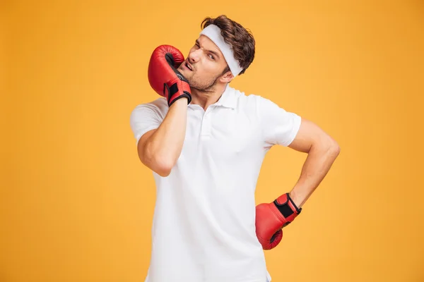 Joven boxeador en guantes rojos de pie y calentando —  Fotos de Stock