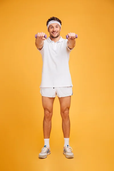 Glad ung Fitness mannen stående och göra övningar med hantlar — Stockfoto