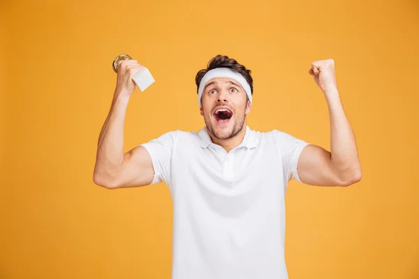 Feliz joven deportista emocionado sosteniendo la copa de trofeo y gritando — Foto de Stock