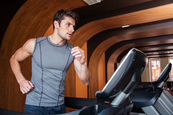 체육관에서 러닝 머신에서 달리는 남자 운동 선수 — 스톡 사진