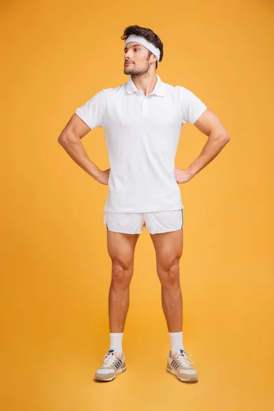 Yakışıklı kendine güvenen genç adam atlet kalçaelleri ile ayakta — Stok fotoğraf