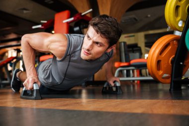 Sporcu spor salonunda push-up egzersizleri yapıyor