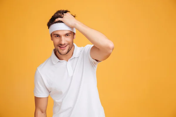 Portrait of smiling attractive young man athlete in headband — Stock Photo, Image