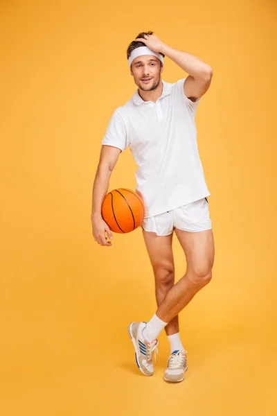 Glada basketspelare står med bollen isolerade — Stockfoto