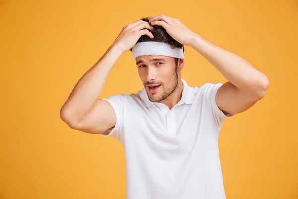 Precioso joven deportista confiado tocando su cabello y posando —  Fotos de Stock