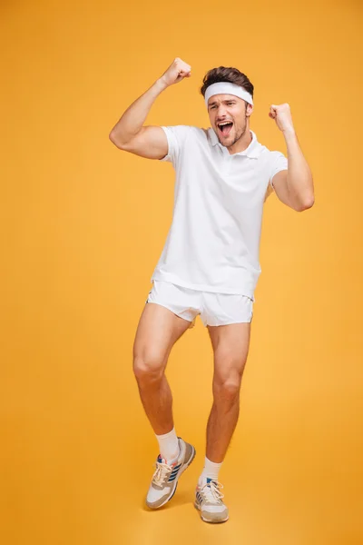 Joven deportista alegre emocionado de pie y celebrando el éxito — Foto de Stock