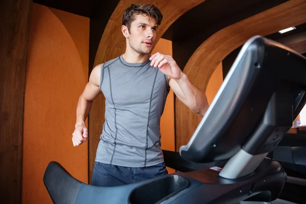 Young man in sportswear running on treadmill at the gym — Stock Photo, Image