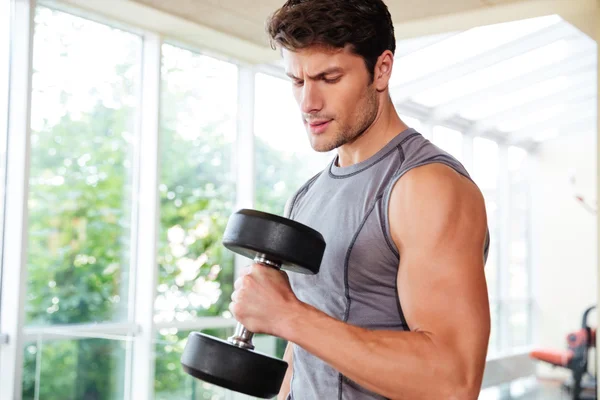 Hombre de fitness haciendo ejercicios con pesas en el gimnasio — Foto de Stock