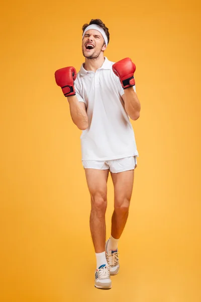 Hombre feliz boxeador en guantes rojos celebrando el éxito y gritando —  Fotos de Stock