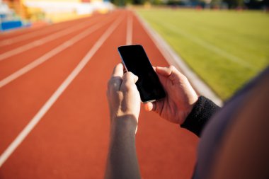 Yakışıklı bir adam dinlenme ve smartphone kullanarak resim kırpılmış