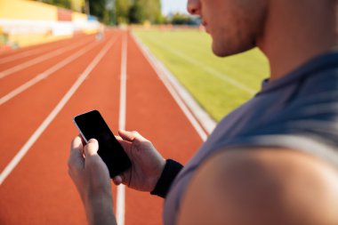 Yakışıklı bir adam dinlenme ve smartphone kullanarak resim kırpılmış