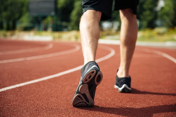 Bijhouden van de benen van de jonge sporter waarop stadion — Stockfoto