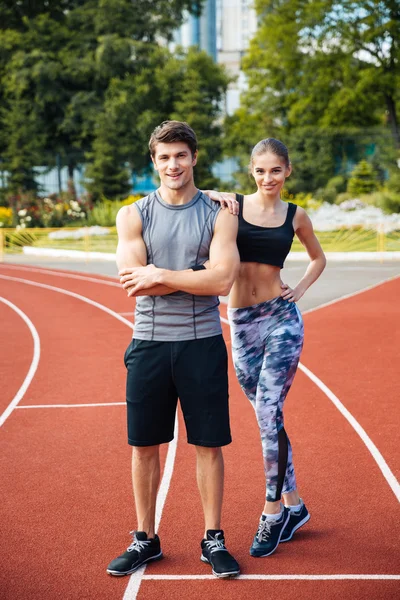 Jovem homem e mulher em pé na pista de atletismo — Fotografia de Stock