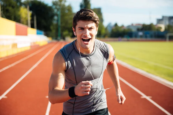 Retrato de um homem do esporte que corre com fones de ouvido — Fotografia de Stock