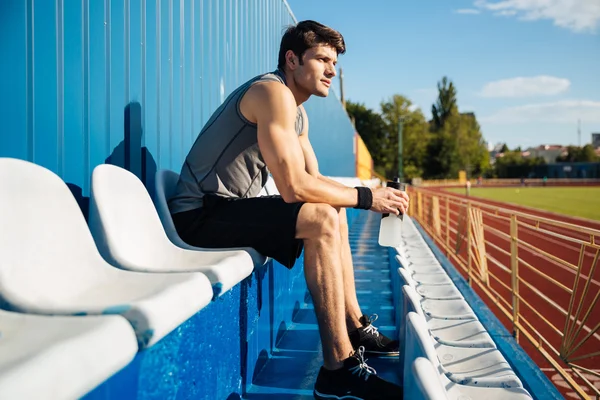 Jovem atleta bonito masculino descansando após o treino — Fotografia de Stock