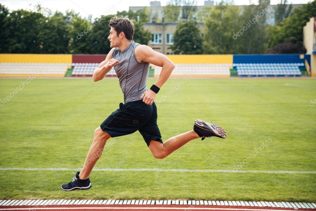 Vista lateral de un velocista corriendo en pistas de atletismo 2022