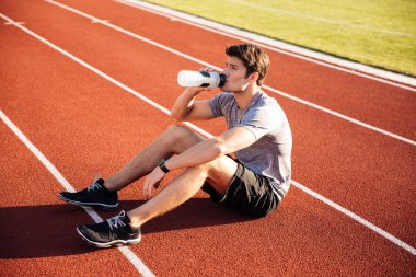 Su şişesi ile dinlenme sporcu genç yakışıklı adam