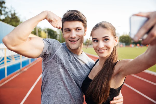 Joven feliz pareja de deportes haciendo foto selfie en el estadio —  Fotos de Stock