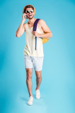 Yürüyüş ve cep telefonu üzerinde konuşurken sırt çantası ile mutlu adam