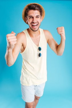 Genç adam ayakta ve başarı kutluyor mutlu heyecanlı